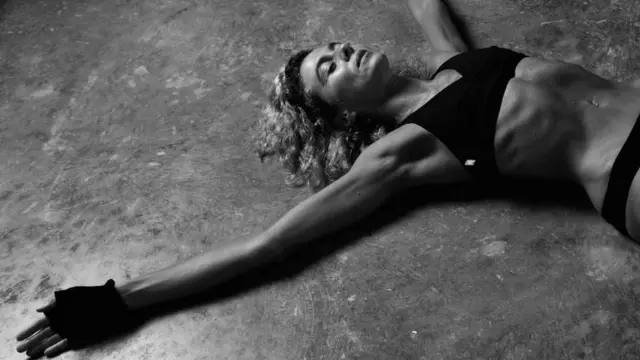 Margarita De Francisco acostada y con ropa deportiva, se ve su cuerpo tonificado.