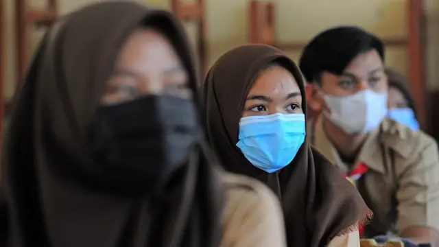 Siswa SMA mengenakan seragam pramuka dan berjilbab