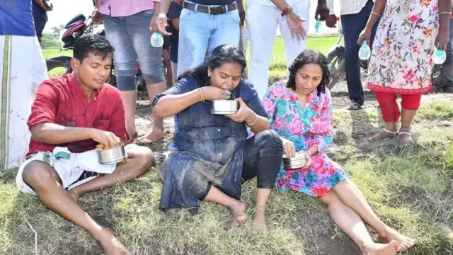 గట్టు మీద కూర్చొని అన్నం తింటున్న కలెక్టర్ దంపతులు