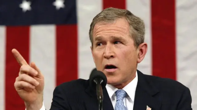 ABD Başkanı George W. Bush, Amerikan bayrağı önünde yaptığı konuşmada sırasında parmağını işaret ediyor.