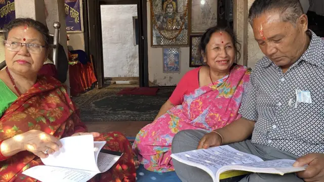 भजनको पुस्तक हेर्दै भजन मण्डलीका सदस्यहरू