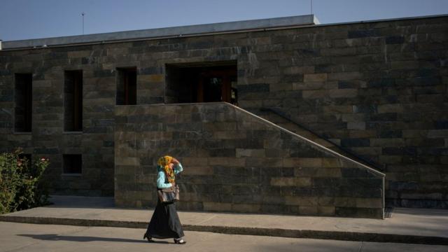Une étudiante passe devant l'entrée du campus de l'université de Kaboul.