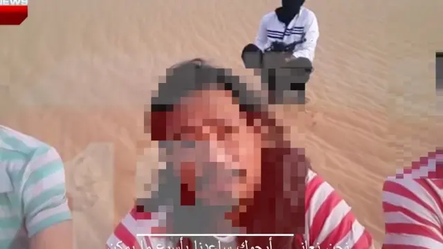 피랍자들 뒤로 무장단체 조직원으로 추정되는 사람이 총을 들고 있다