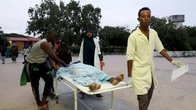 Paramédicos y civiles llevan a una persona herida al Hospital Madina después de una explosión en el hotel Elite.