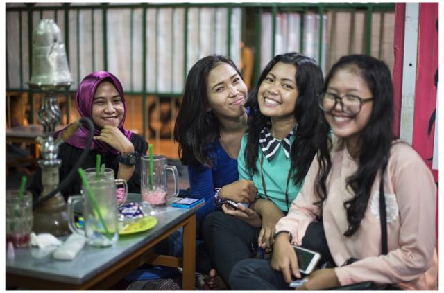 A group of Indonesia girls are seen drinking tea and smoking shisha at a Warkop after school ended.