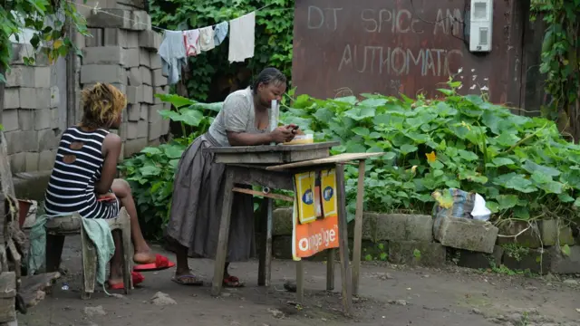 People gather outside dia house for Buea, wey no far from Douala.