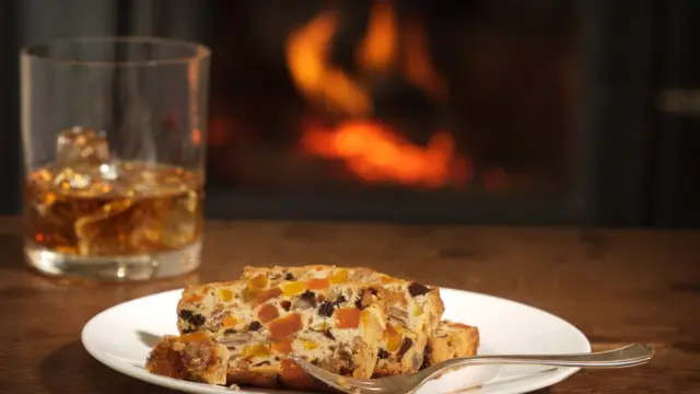 Стакан виски и ломоть фруктового пирога.