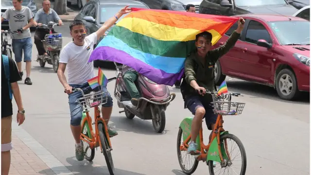 6月21日,山西太原,兩名民間同性戀團體成員舉著"彩虹旗"在街頭騎行。