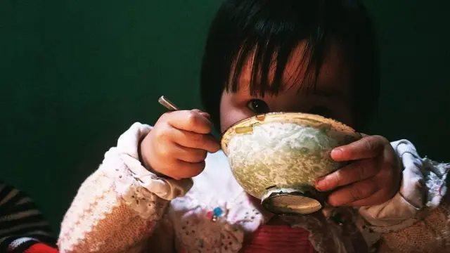 Niño comiendo arroz