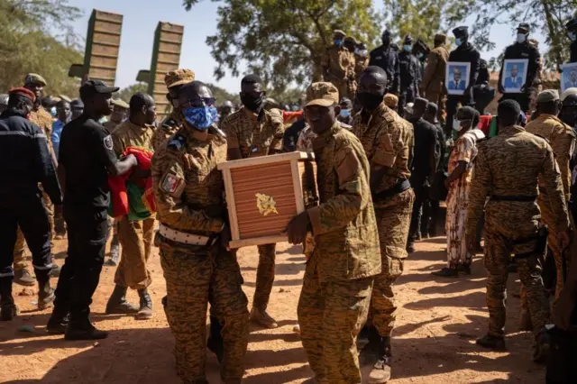 Des responsables militaires portent le cercueil d'un soldat burkinabé tué lors de l'attaque d'un camp de gendarmerie à Inata le 14 novembre 2021, dans la section militaire du cimetière de Gounghin à Ouagadougou, le 23 novembre 2021. (Photo par OLYMPIA DE MAISMONT / AFP) (Photo par OLYMPIA DE MAISMONT/AFP via Getty Images)