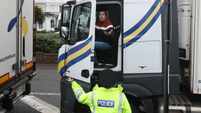 A police officer talks to an exasperated lorry driver outside the Port of Dover in Kent on Monday