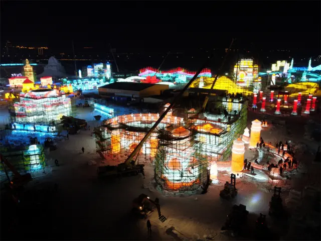Workers build ice structures at night