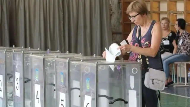 Жінка вкидає бюлетень