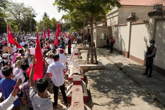 很多人手举标语和昂山素季所在政党缅甸全国民主联盟的旗帜表达不满。