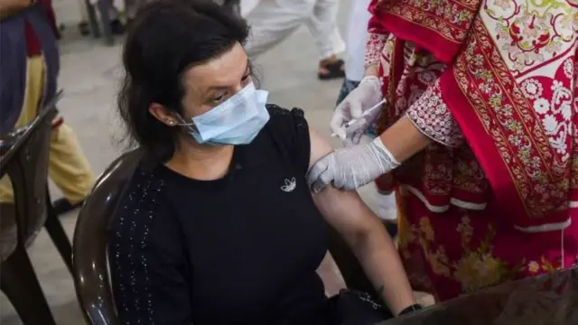 د پاکستان کراچۍ کې یوه مېرمن کورونا واکسین کوي.