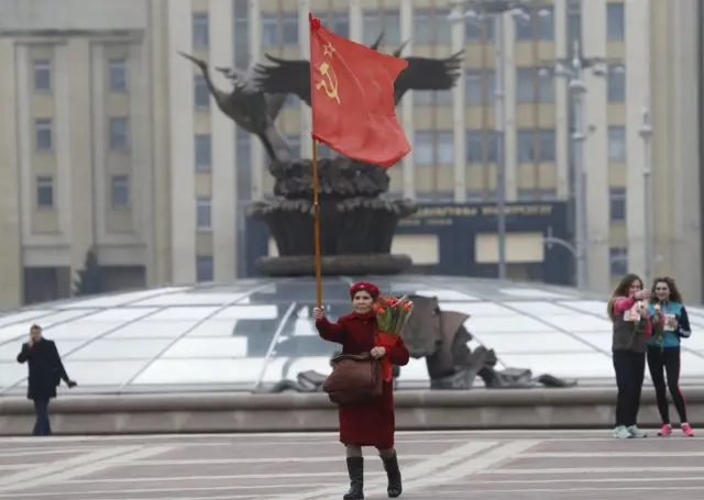 Aynı kentte yaşlı bir komünist kadın ise 8 Mart'ı tek başına, elinde Sovyetler Birliği bayrağıyla kutladı.