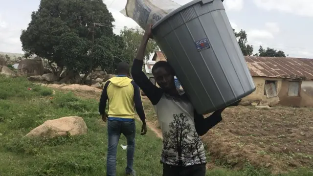 One man cari big bucket dey go