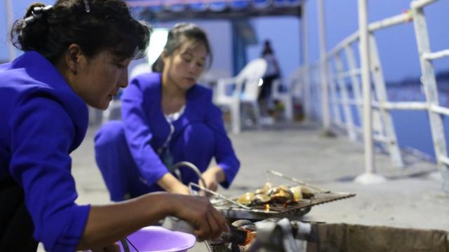 Dos mujeres asando almejas