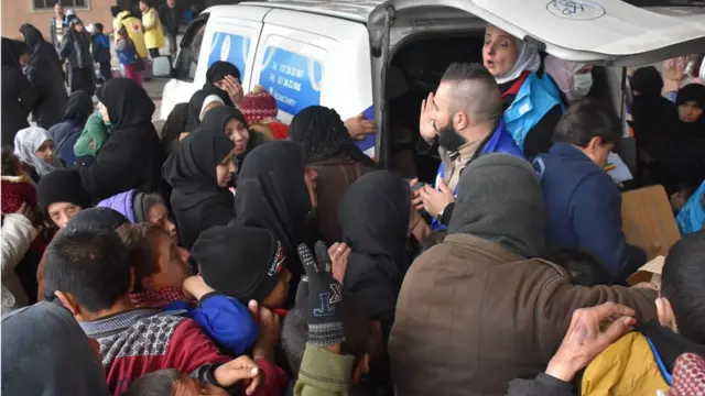 صورة سوريين فارين من القتال يتلقون مساعدات