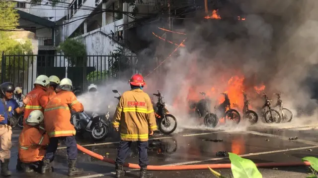 เจ้าหน้าที่ช่วยกันดับเพลิงหลังเกิดเหตุระเบิดที่โบสถ์แห่งหนึ่งในสุราบายา เมื่อวันอาทิตย์