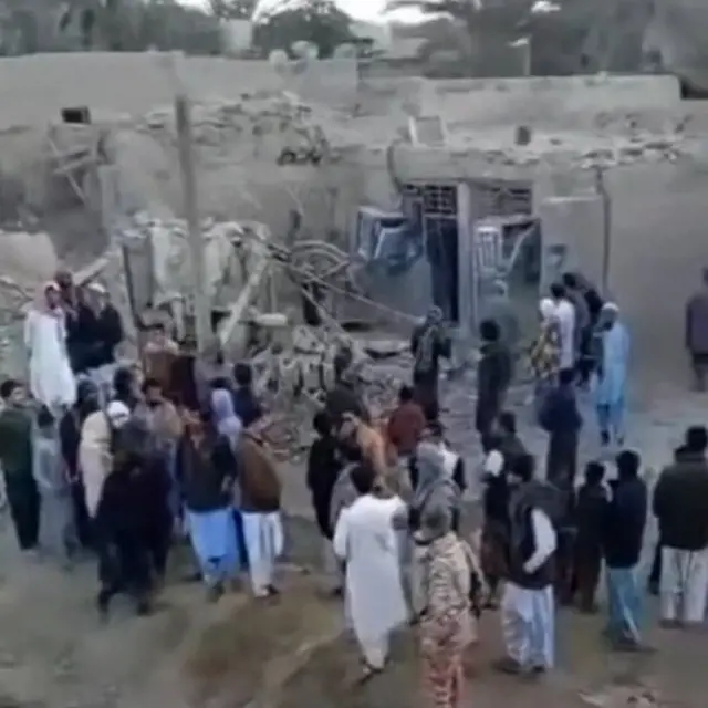People gather near rubble in the aftermath of Pakistan's military strike on an Iranian village near Saravan, Sistan and Baluchestan Province, Iran