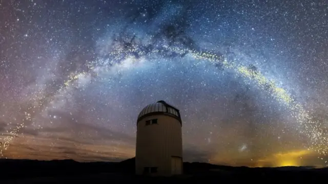 Telescopio con la Vía Láctea de fondo.