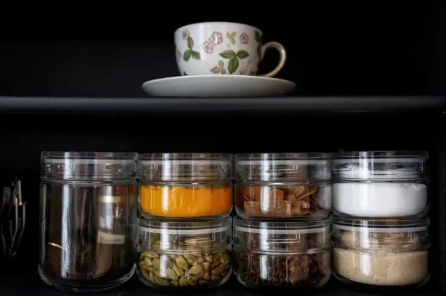 Frascos con especias y una taza en el armario de la cocina de la minimalista Saeko Kushibiki, en Fujisawa