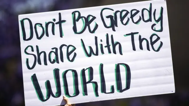 Un cartel en el que se pide que se compartan las vacunas