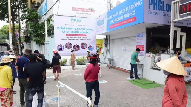 Người dân đứng xếp hàng lấy gạo vẫn đảm bảo khoảng cách 2 mét.