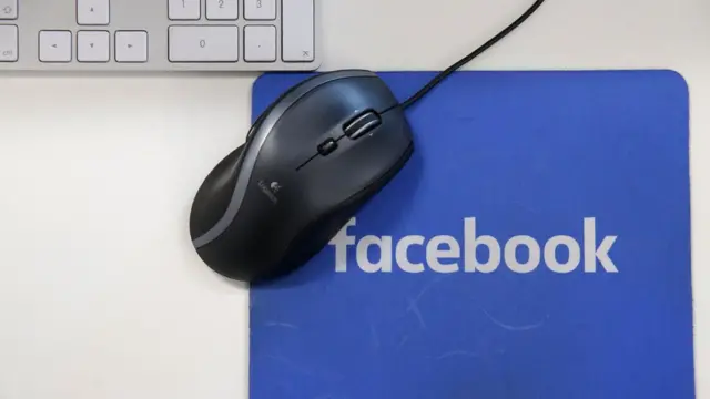 ફેસબુકના લોકો સાથેના માઉસ પેડ પર માઉસ અને બાજુમાં કિ બોર્ડ