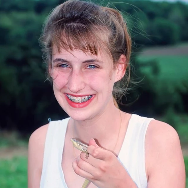 Ekren holding a lizard as a child