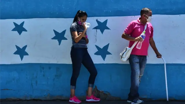 Hondureños ante la bandera nacional.