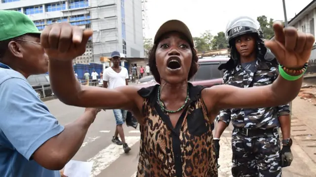 People celebrate outside the Court on March 26, 2018 in Freetown after Sierra Leone's High Court lifted an order that had halted the country's presidential runoff because of a complaint of electoral fraud backed by the ruling party
