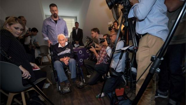 Australian scientist David Goodall leaves in a wheelchair after a press conference