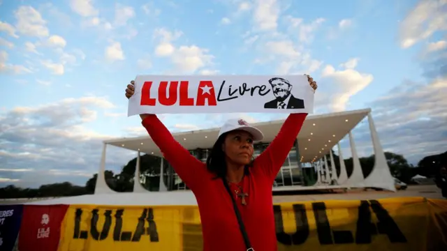 Manifestanteesporte fcfrente segura cartaz dizendo: "Lula Livre"