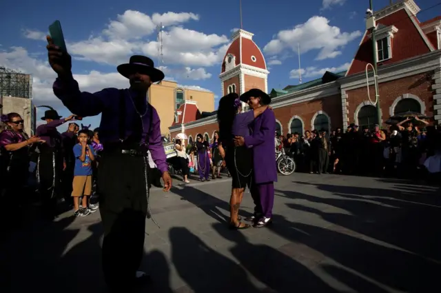 The crowd watches a successful wedding proposal taking place between a couple dressed as "Pachucos" during the Quinceanera (15th birthday) of a teenager in downtown Ciudad Juarez, Mexico, 5 August 2017.