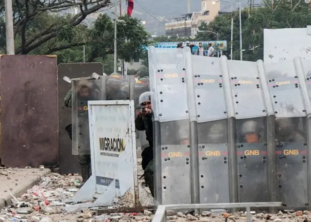 Pengunjuk rasa melempar batu ke arah pasukan keamanan Venezuela yang memblokade jembatan internasional Francisco de Paula Santander, yang menghubungkan Venezuela dan Kolombia.