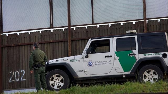Un guardia de Estados Unidos junto a una valla en la frontera con México.