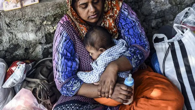 Mujer con su bebé y un tetero.
