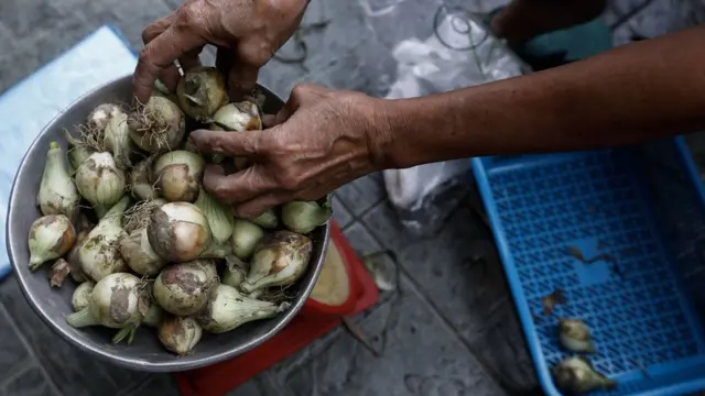 Pessoa coloca cebolassorteesportiva comuma balançasorteesportiva comQuezon City, Metro Manila, Philippines,sorteesportiva com10sorteesportiva comjaneirosorteesportiva com2023