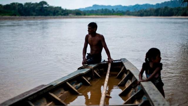 Dos niños en un bote sobre el caudaloso Amazonas