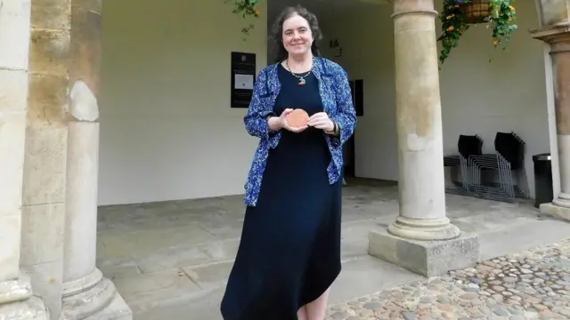 Philippa Steele, especialistaapps de palpites de futebolescritos antigos da Universidadeapps de palpites de futebolCambridge, no Reino Unido, com a tábuaapps de palpites de futebolargila que contém uma mensagem para o futuro