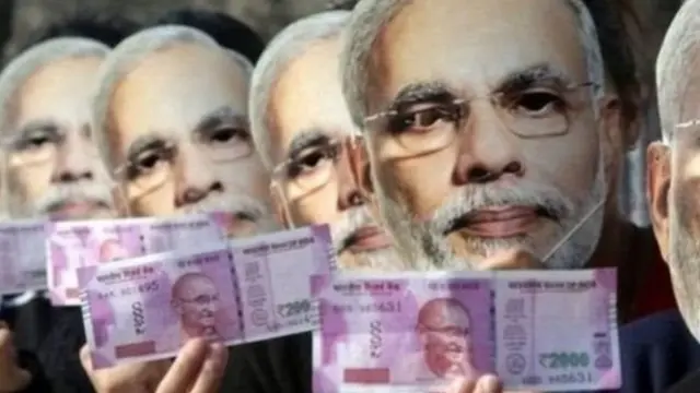 मोदी के मुखौटों के साथ करेंसी नोट लिए लोग