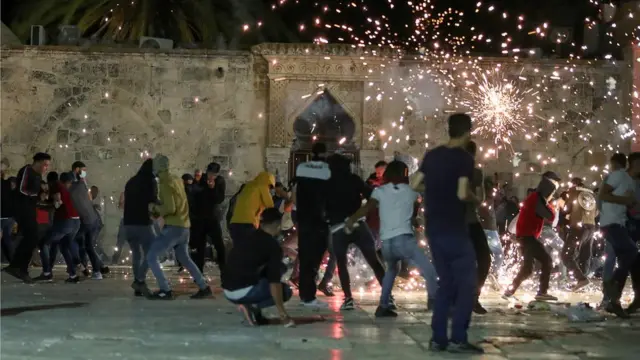 Des Palestiniens réagissent à des tirs de grenades assourdissantes par la police israélienne lors d'affrontements dans l'enceinte de la mosquée al-Aqsa, dans la vieille ville de Jérusalem (7 mai 2021)