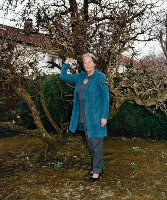 Renée al lado de un árbol