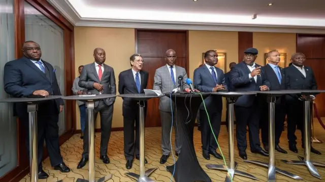 Bwana Fayulu (uri hagati imbere y'indangururamajwi) ubwo yari mu kiganiro n'abanyamakuru gihuriweho ku cyumweru, amaze kugenwa nk'umukandida w'abatavuga rumwe na leta ya Kongo