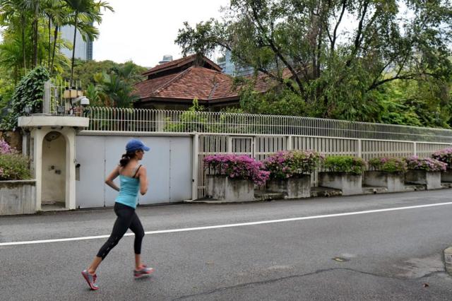 A woman jogs past the house of Singapore"s late prime minister Lee Kuan Yew on 38 Oxley Road in Singapore on 3 July 2017.