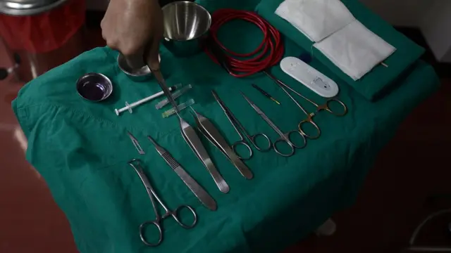 ผู้ช่วยกำลังจัดเตรียมอุปกรณ์ในการผ่าตัดศัลยกรรมเปลือกตา