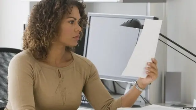 ઓફિસમાં કોઈ પત્ર કે દસ્તાવેજ વાંચી રહેલી કન્યાની પ્રતીકાત્મક તસ્વીર