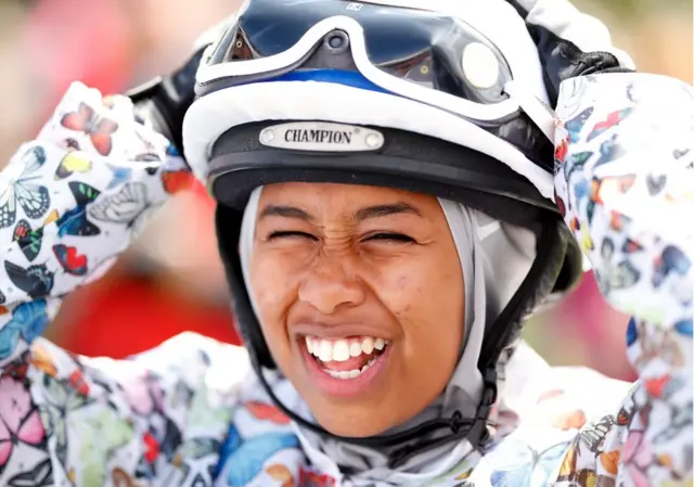 Jokey Khadijah Mellah, İngiltere'de düzenlenen Qatar Goodwood Festivali'nde Manolya Kupası'nı kazanmadan hemen önce. Kendisinin İngiltere'de bir at yarışına başörtüsü takarak çıkan ilk kadın olduğu düşünülüyor.